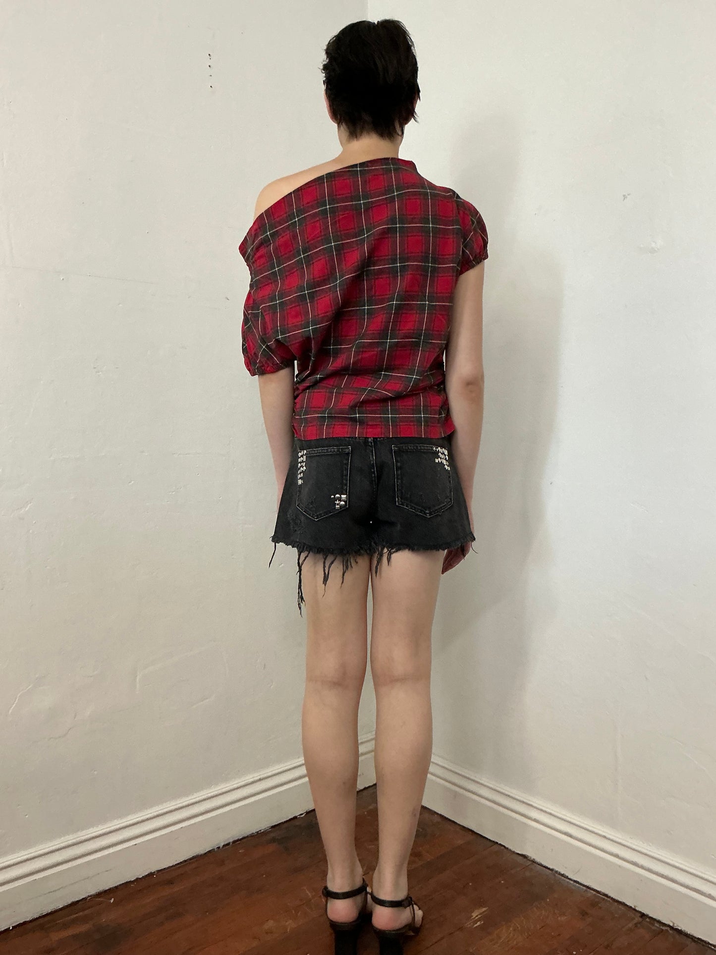 Asymmetrical off shoulder rushed plaid top with a mineral wash.