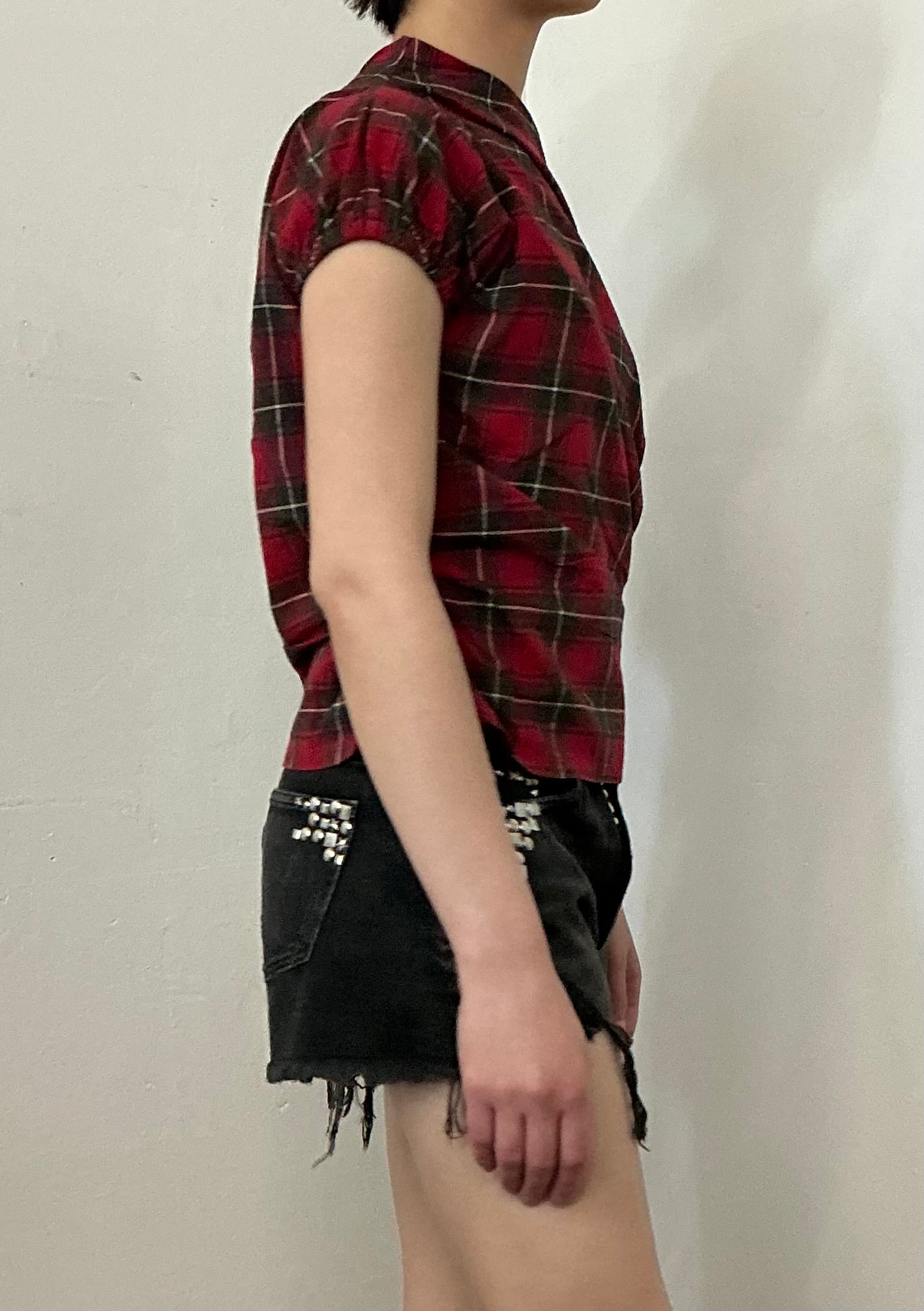 Asymmetrical off shoulder rushed plaid top with a mineral wash.