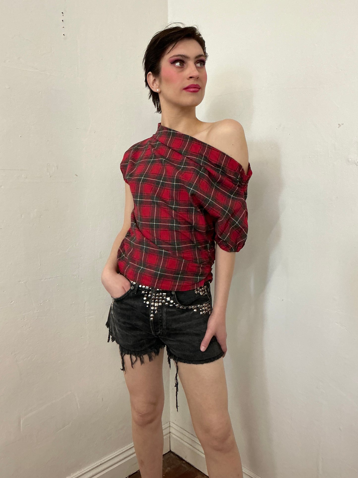 Asymmetrical off shoulder rushed plaid top with a mineral wash.