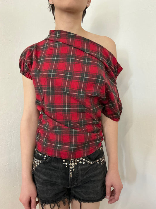 Asymmetrical off shoulder rushed plaid top with a mineral wash.