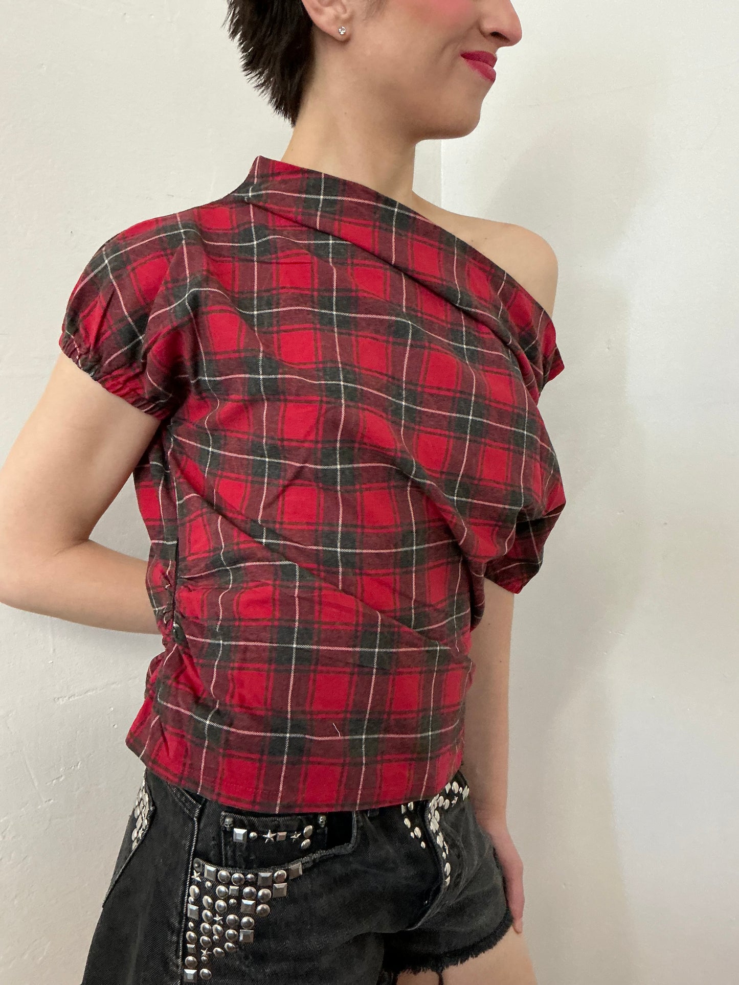 Asymmetrical off shoulder rushed plaid top with a mineral wash.