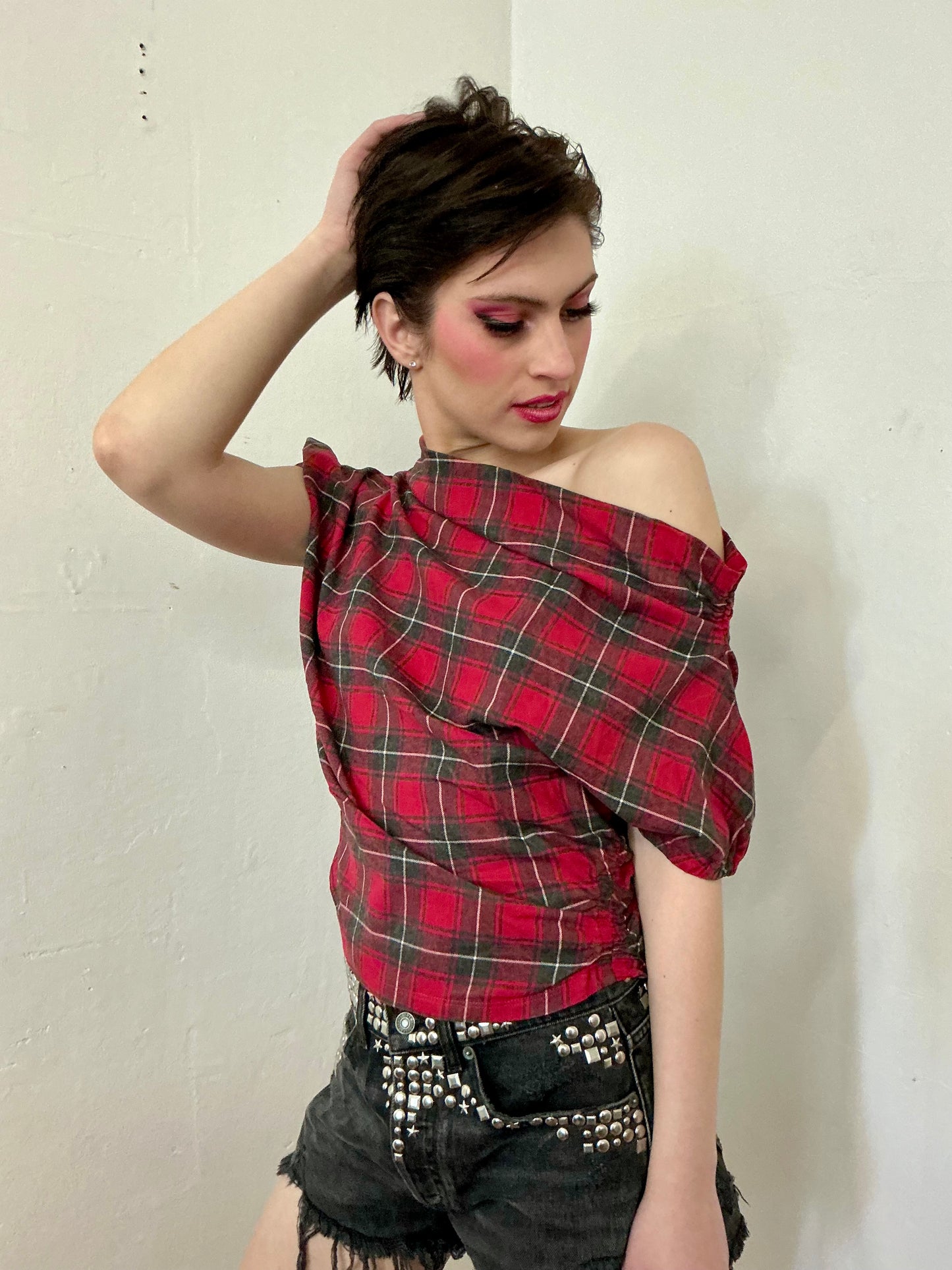Asymmetrical off shoulder rushed plaid top with a mineral wash.