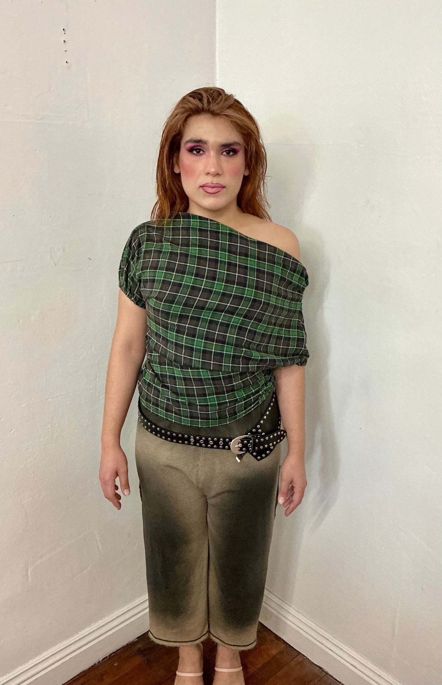 Asymmetrical off shoulder rushed plaid top with a mineral wash.
