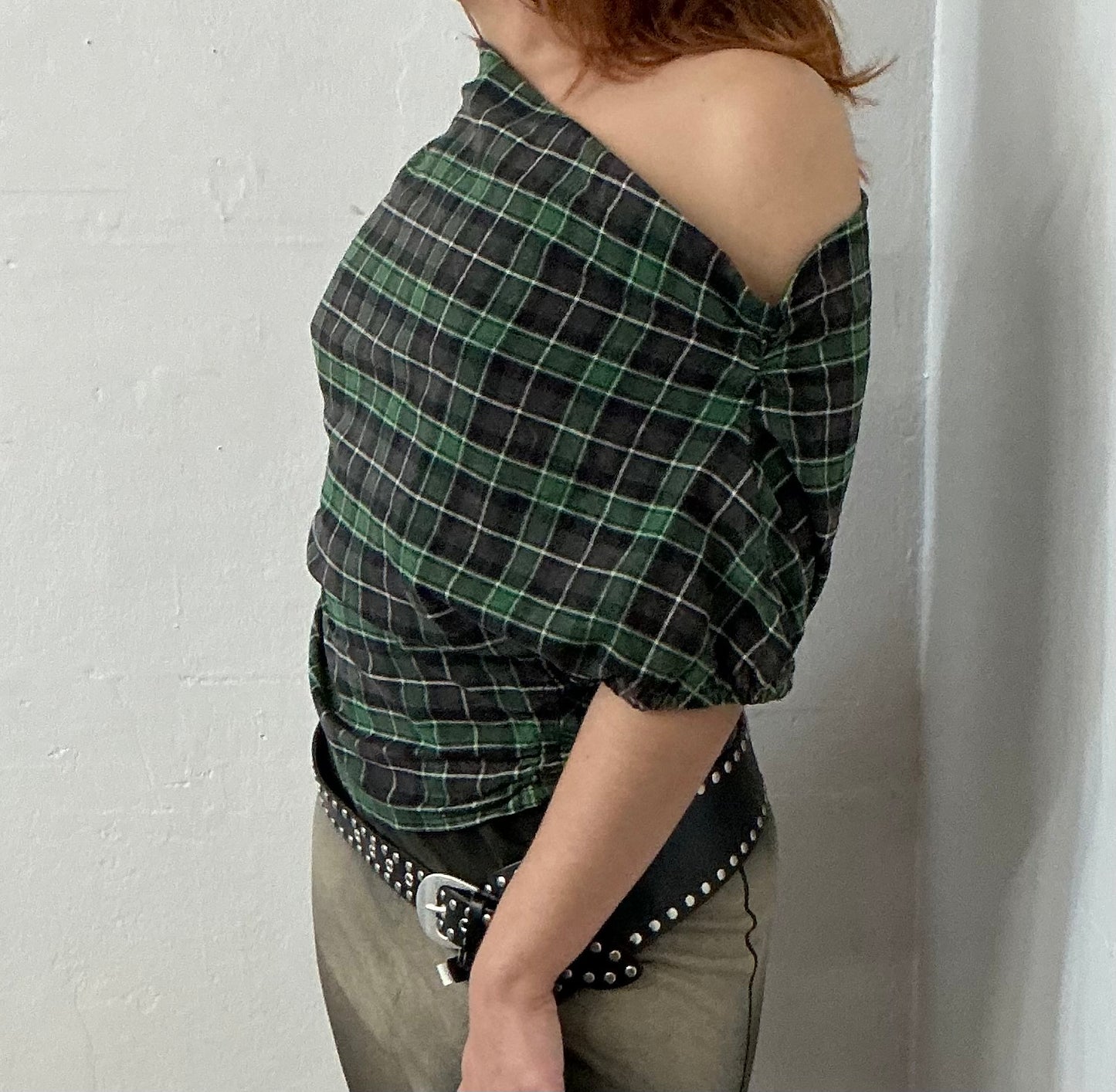 Asymmetrical off shoulder rushed plaid top with a mineral wash.